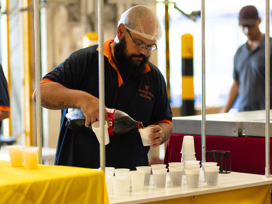 Equipe operacional servindo bebidas na estrutura de alimentação montada para o evento