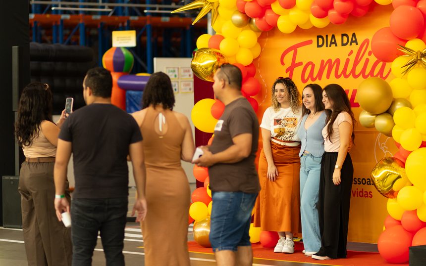 Colaboradores registrando fotos no painel personalizado da ativação interna da companhia